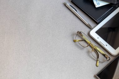 Üzerinde gerekli eşyalar olan gri bir yüzey. Kalemle günlük, Samsung telefonu. Bir fincan beyaz kahve. Kopyalama alanı olan üst görünüm,