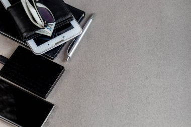 Üzerinde gerekli eşyalar olan gri bir yüzey. Kalemle günlük, Samsung telefonu. Bir fincan beyaz kahve. Kopyalama alanı olan üst görünüm,