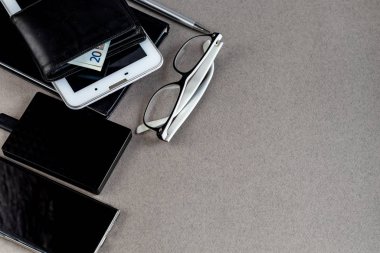 Üzerinde gerekli eşyalar olan gri bir yüzey. Kalemle günlük, Samsung telefonu. Bir fincan beyaz kahve. Kopyalama alanı olan üst görünüm,