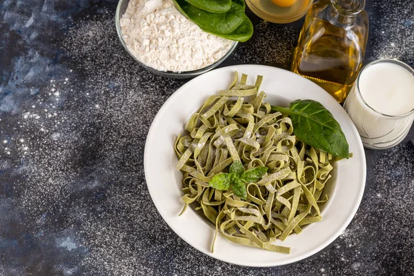 Pasta, verdure, erbe e spezie, olio d'oliva, ingredienti per la cucina italiana su sfondo scuro . — Foto Stock