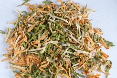Pasta, vegetables, herbs and spices, olive oil, ingredients for Italian cuisine against white background.