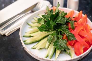 Fresh vegetables and herbs. Ingredients for the salad. Cucumbers tomatoes Bulgarian pepper with spinach, parsley. On a wooden background.