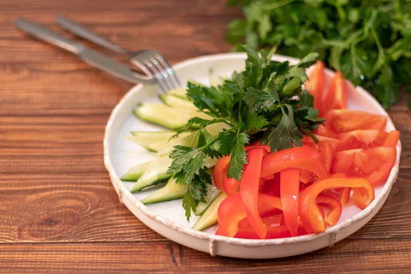 Fresh vegetables and herbs. Ingredients for the salad. Cucumbers tomatoes Bulgarian pepper with spinach, parsley. On a wooden background. — Stockfoto