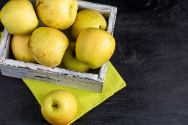 Golden apples are collected in a wooden, light, natural, environmentally friendly box. Harvesting. Delicacy for guests, vegetarian food, healthy food.