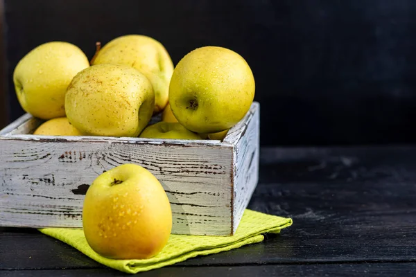 Golden apples are collected in a wooden, light, natural, environmentally friendly box. Harvesting. Delicacy for guests, vegetarian food, healthy food. — Stock Photo, Image