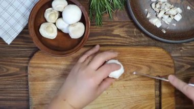 Slicing ingredients for a rice dish with vegetables. Vegetarian dish. Mushrooms and carrots onions. Healthy diet. On a wooden background.