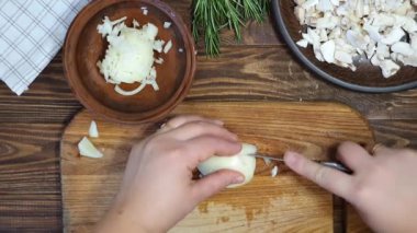 Slicing ingredients for a rice dish with vegetables. Vegetarian dish. Mushrooms and carrots onions. Healthy diet. On a wooden background.