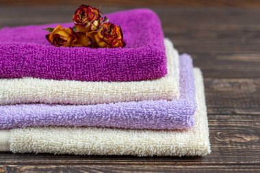 Terry güzellik ve sağlık için havlu. Bir yığın çok renkli havlu ahşap bir arka planda yatıyor. Yaşam tarzı, ev işi resmi.