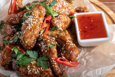 Soya soslu tavuk kanadı. Bira için servis edildi. Susam tohumları serpin. Biber sosu ve domateslerin yanında. Tahtada..