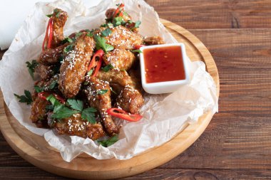 Soya soslu tavuk kanadı. Bira için servis edildi. Susam tohumları serpin. Biber sosu ve domateslerin yanında. Tahtada..