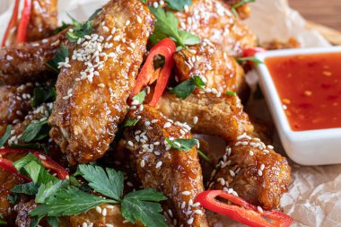 Soya soslu tavuk kanadı. Bira için servis edildi. Susam tohumları serpin. Biber sosu ve domateslerin yanında. Tahtada..