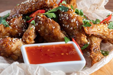 Soya soslu tavuk kanadı. Bira için servis edildi. Susam tohumları serpin. Biber sosu ve domateslerin yanında. Tahtada..