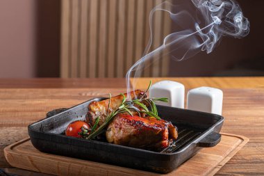 Biberiye ve domatesli ızgara sığır filetosu. Tahta bir masada..