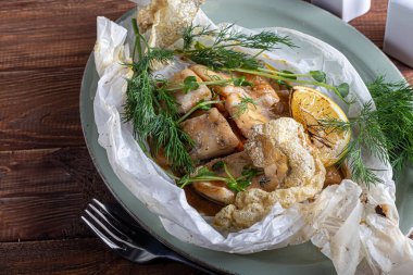 Sebze yastığında pişirilmiş fırın. Yeşillikle süslenmiş..