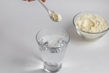 Kolajen tozu ölçüm kaşığıyla bir bardağa konur. Dondurulmuş kare Ek protein alımı. Güzellik ve sağlık için doğal takviyeler. Kolajen bazlı bitki konsepti. Flatlay, üst manzara. Boşluğu kopyala