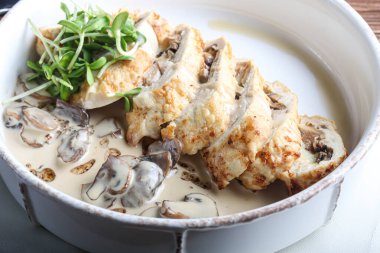 Mantarlı tavuk göğsü. Şampiyon sosunun yanında. Karanlık bir arka planda. Mikro yeşille süslenmiş. Boşluğu kopyala