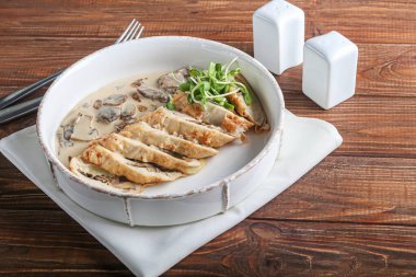 Mantarlı tavuk göğsü. Şampiyon sosunun yanında. Karanlık bir arka planda. Mikro yeşille süslenmiş. Boşluğu kopyala