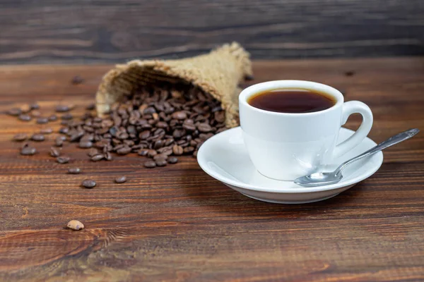 Una Tazza Caffè Bianco Uno Sfondo Legno Chicchi Caffè Sono — Foto Stock