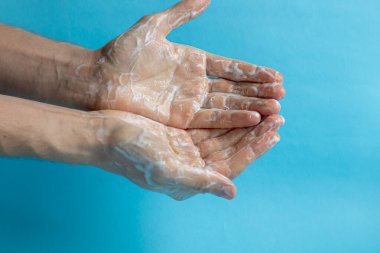 Bir adam ellerini sabunla yıkıyor ve ellerini temizlemek ve dezenfekte etmek için antiseptik kullanıyor. Virüs Önleme, Coronovirus. Hijyen konsepti el detayı. Saflık.