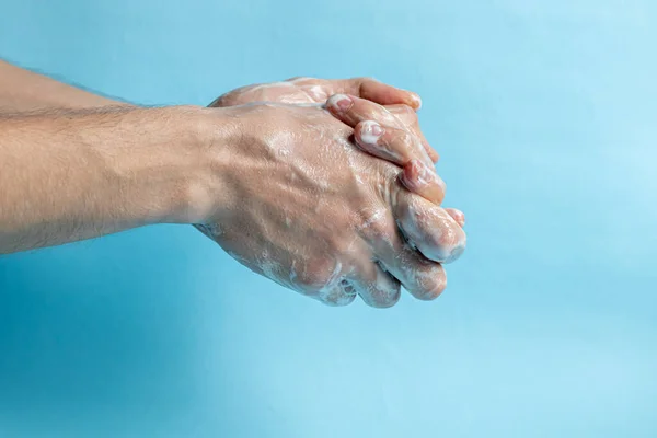 A man washes his hands with soap and uses an antiseptic to clean and disinfect his hands. Virus Prevention, Coronovirus. Hygiene concept hand detail. Purity.
