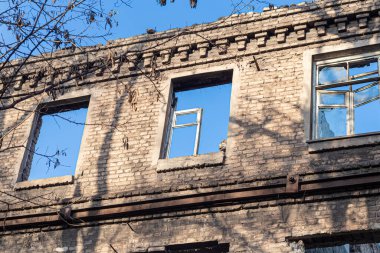 Harap olmuş eski bir ev. Ve mavi gökyüzü. Eski evlerin kalıntıları. Terk edilmiş şehir. Hayaletler şehri. Eski tarihi binaların yıkıntıları deprem tarafından yok edildi. Kırık bina.