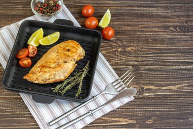 Fırında ızgara tavada tavuk göğsü pişirdim. Yakınlarda vişneli domates, kuru biberiye, limon ve biberli mısır var. Beslenme düzeni. Boşluğu kopyala