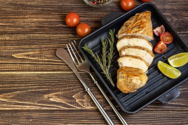 Fırında ızgara tavada tavuk göğsü pişirdim. Yakınlarda vişneli domates, kuru biberiye, limon ve biberli mısır var. Beslenme düzeni. Boşluğu kopyala