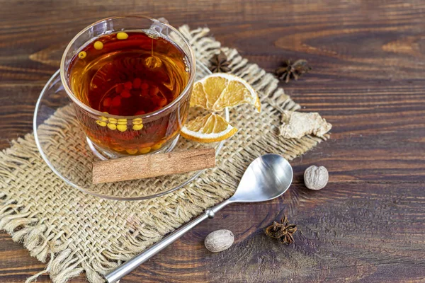 Şeffaf bir fincanda deniz dikenli çay. Vitamin içeceği. Virüs enfeksiyonuna karşı bağışıklığı arttırır. Baharatların yanında, tiramisu keki. Boşluğu kopyala