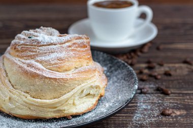 Kuru üzüm ve kuru meyveli fırın ürünleri koyu ahşap arka planda yer almaktadır. Üzerine krema serpilmiş şeker. Kraffinler. Paskalya yemeği. Boşluğu kopyala