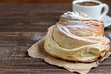 Kuru üzüm ve kuru meyveli fırın ürünleri koyu ahşap arka planda yer almaktadır. Üzerine krema serpilmiş şeker. Kraffinler. Paskalya yemeği. Boşluğu kopyala