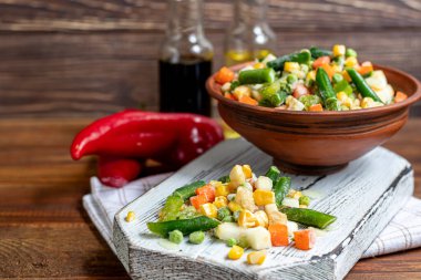 Donmuş sebzeler. Donmuş sebze karışımı havuç, mısır ve bezelye, kereviz ve mısır. Meksika karışımı. Ahşap bir arka planda. Boşluğu kopyala