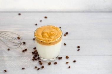 Dalgona kahvesi soğuk Kore içeceğidir. Lezzetli, aromatik kahve sütlü ve şekerli beyaz arka planda bir bardak. Boşluğu kopyala