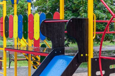 Yağmurda çocuk parkında boş salıncak. Parkta çocuk salıncağı, ahşap banklar, slaytlar, spor malzemeleri. Boş şehir, karantina. Yalnızlık kavramı.