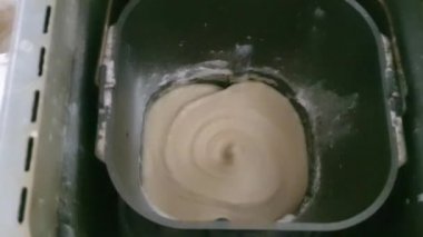 Ekmek makinesinde hamur yapmak. Diz çökme işlemi. Katkı maddeleri, un ve maya. Taze ev yapımı ekmek..