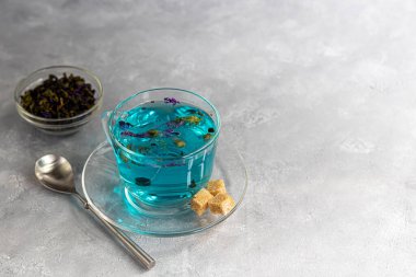 Bir fincan sıcak, bezelye çiçekli mavi çay. Mavi bezelye. Sağlıklı içmek, vücudu zehirden arındırmak için. Gri arka plan. Boşluğu kopyala