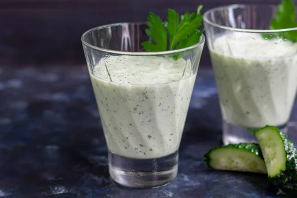 Koyu arkaplanda salatalık, maydanoz ve kefir soslu meyve suyu. Sağlıklı beslenme, diyet. Boşluğu kopyala.