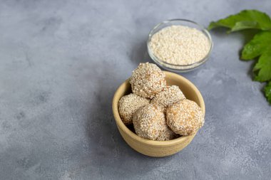 Pişirmeden enerji ısırıkları malzemelerden yapılır - fındık, kakao, çikolata, yulaf ve susam tohumları. Gri bir arka planda. Boşluğu kopyala