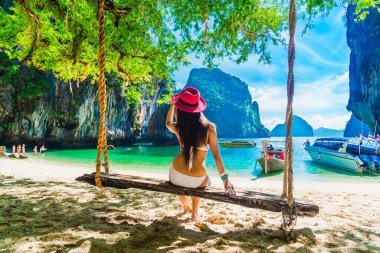 Traveler woman in bikini relaxing on swing joy nature scenic bea clipart