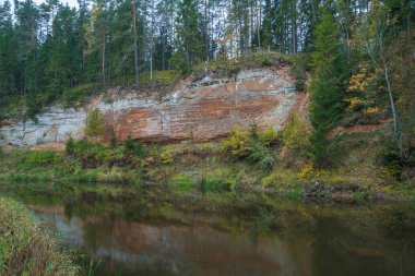 Kırmızı kayalıklarla City Masalaca, Letonya.