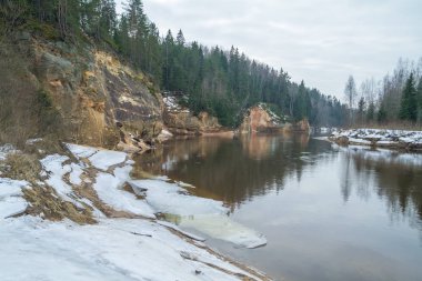 Kış kırmızı kayalıklarla, Letonya.