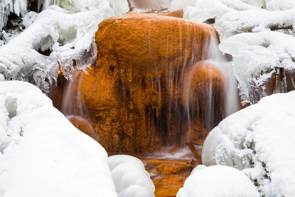 Red rock waterfall and  ice at Latvia. Travel photo. 2018