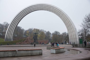 Şehir, Kiev, Ukrayna. Demir kemer ve anıt. Etrafta turistler dolaşıyor.