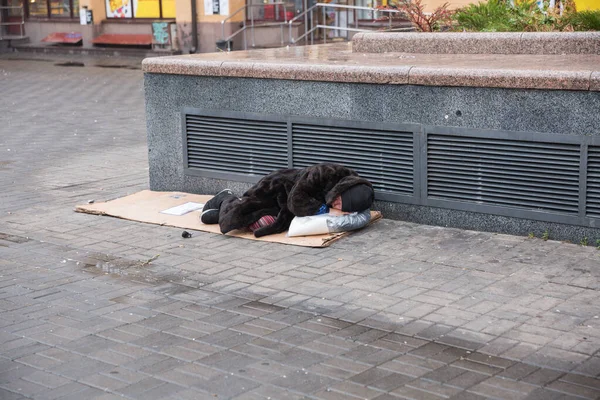 City, Kiev, Ukraine. Homeless person is lying on the street. Cit — Stock Photo, Image