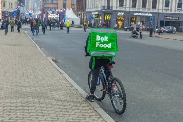 Ciudad Riga, Letonia. Entrega rápida de comida en bicicleta. Un ciclista s — Foto de Stock