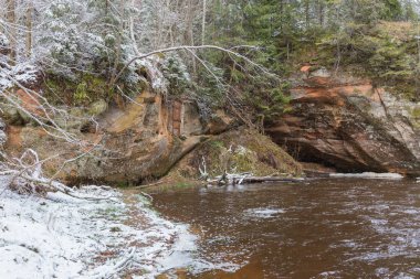 Ligatne Şehri, Letonya. Kışın kumtaşı kayalıkları ve mağaraları olan nehir. 14.03.2020