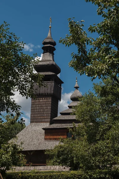 Iglesia Lemk de madera vieja contra un cielo azul brillante con nubes . — Foto de Stock