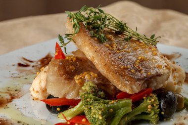 Fried sebzeler üzerinde beyaz balık fileto.