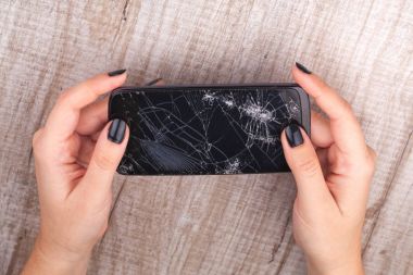 Kızın elinde kırık bir ekran ile Smartphone