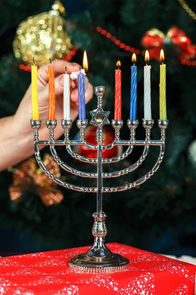 Menora mit Kerzen für Chanukka auf dem Hintergrund des Neujahrsbaums — Stockfoto