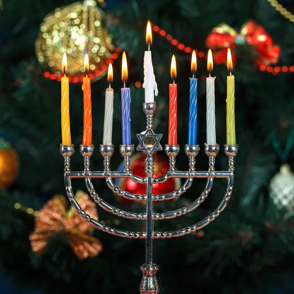 Menorah med ljus för Hanukkah på bakgrunden av trädet nyår — Stockfoto